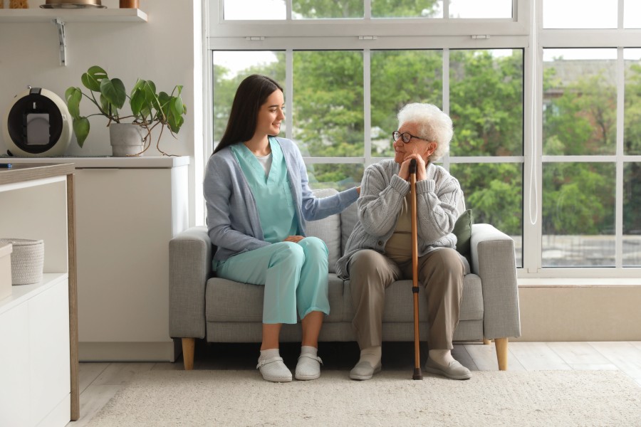 Caregiver holding hands with elderly patient at home